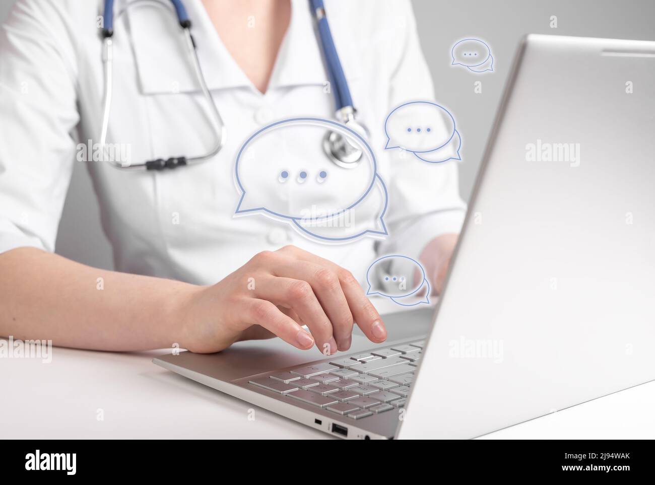 Online medical consultation. Doctor using laptop for chatting with patients remotely and giving answers about general health concerns. Woman with stethoscope sitting at table with computer. photo Stock Photo
