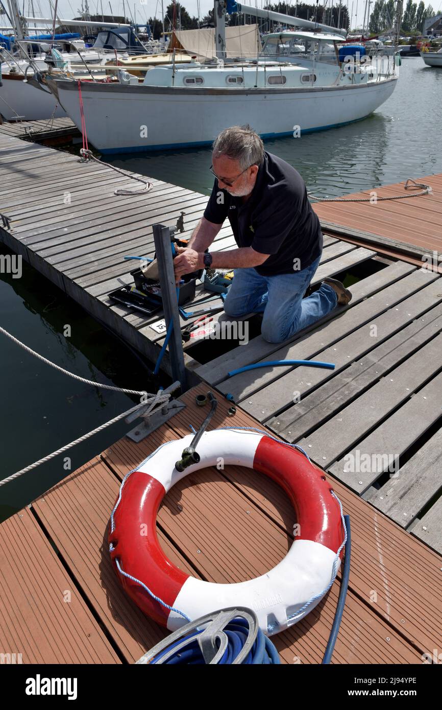 plumber at work on boating marina pontoon lowestoft cruising club oulton broad suffolk england Stock Photo