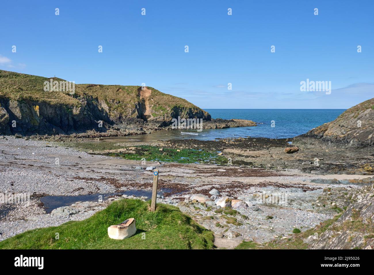 The Wales Coast Path follows the rugged coastline of the northern Llyn Peninsula through a rocky cove Stock Photo