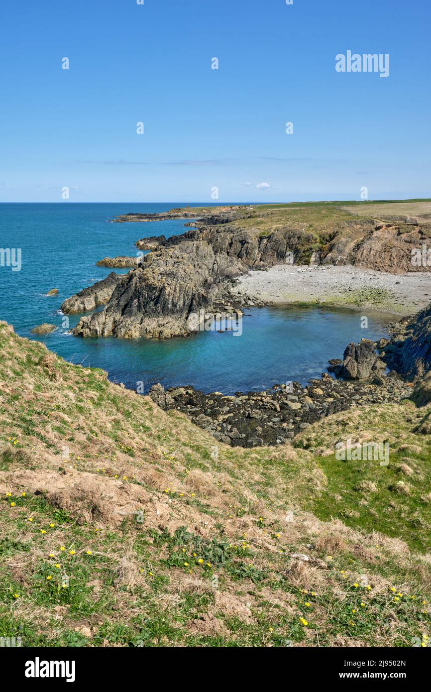 The Wales Coast Path follows the rugged coastline of the northern Llyn Peninsula around a rocky cove Stock Photo