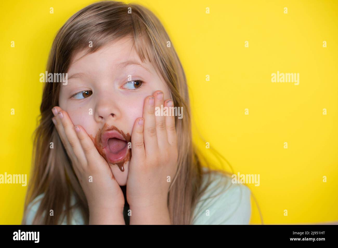 Frightened little girl eating chocolate dirty face Stock Photo