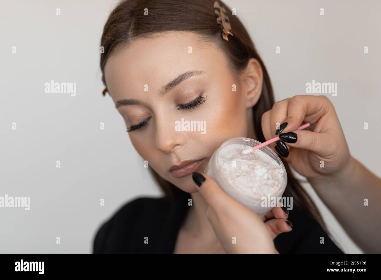 Woman face in spa salon laying and correcting and brushing eyebrows by brush with gel, checking brow eye line. Close up Stock Photo