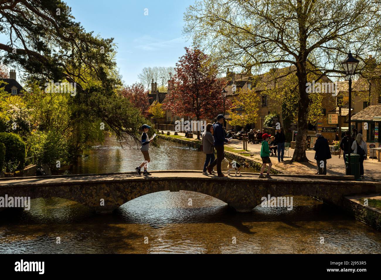 Sightseeing tourists in Bourton-on-the-Water, famous for its low stone bridges across the river Windrush, Cotswolds, Gloucestershire, England, UK. Stock Photo