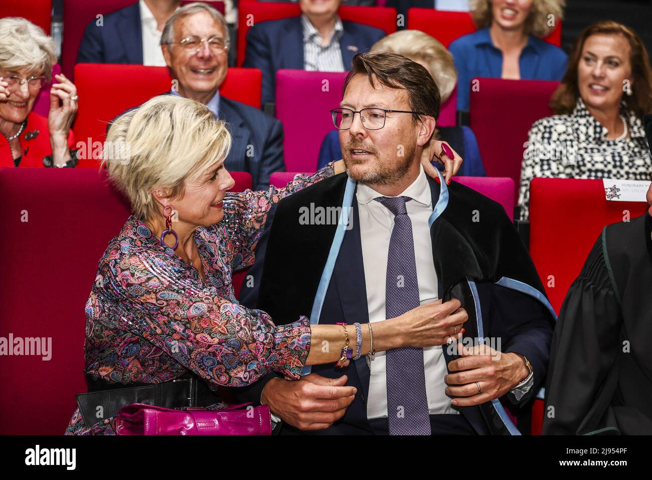 2022-05-20 16:42:00 ENSCHEDE - Princess Laurentien corrects the kappa of  Prince Constantijn after receiving an honorary doctorate at the University  of Twente, which is celebrating her 60th birthday. In the background Jantien