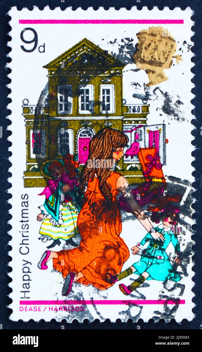 GREAT BRITAIN - CIRCA 1968: a stamp printed in the Great Britain shows Girl Playing with Dolls and Dollhouse, Happy Christmas, circa 1968 Stock Photo