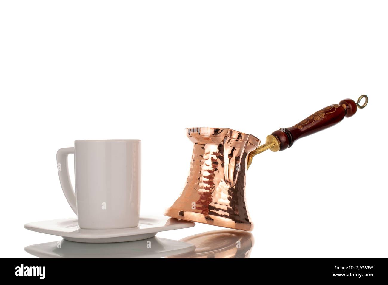 One Turkish Cezve copper coffee pot with white ceramic cup, close-up