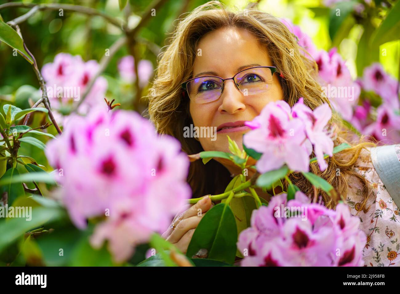 Portrait of a woman among large white flowers in the garden in spring. Stock Photo