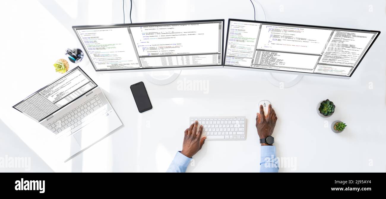 Computer programmer writing program code on computer in office Stock Photo