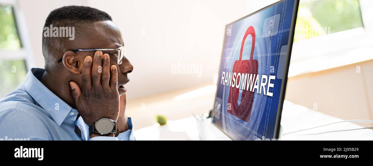 Worried Businessman Looking At Computer With Ransomware Word On The ...