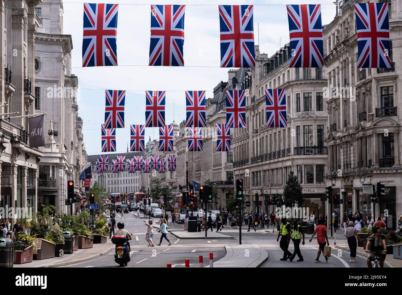 Union Flags hanging high above Regent Street in celebration of Queen Elizabeth IIs upcoming Platinum Jubilee on 17th May 2022 in London, United Kingdom. In 2022, Her Majesty The Queen Elizabeth II will become the first British Monarch to celebrate a Platinum Jubilee to mark the 70th anniversary of her accession to the throne on 6 February 1952. Oxford Street is a major retail centre in the West End of the capital and is Europes busiest shopping street with around half a million daily visitors to its approximately 300 shops, the majority of which are fashion and clothing stores. Stock Photo