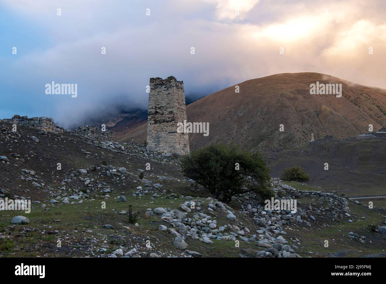 Ancient Ossetian battle tower against a foggy sunset. Verhniy Fiagdon. Northern Ossetia, Russia Stock Photo