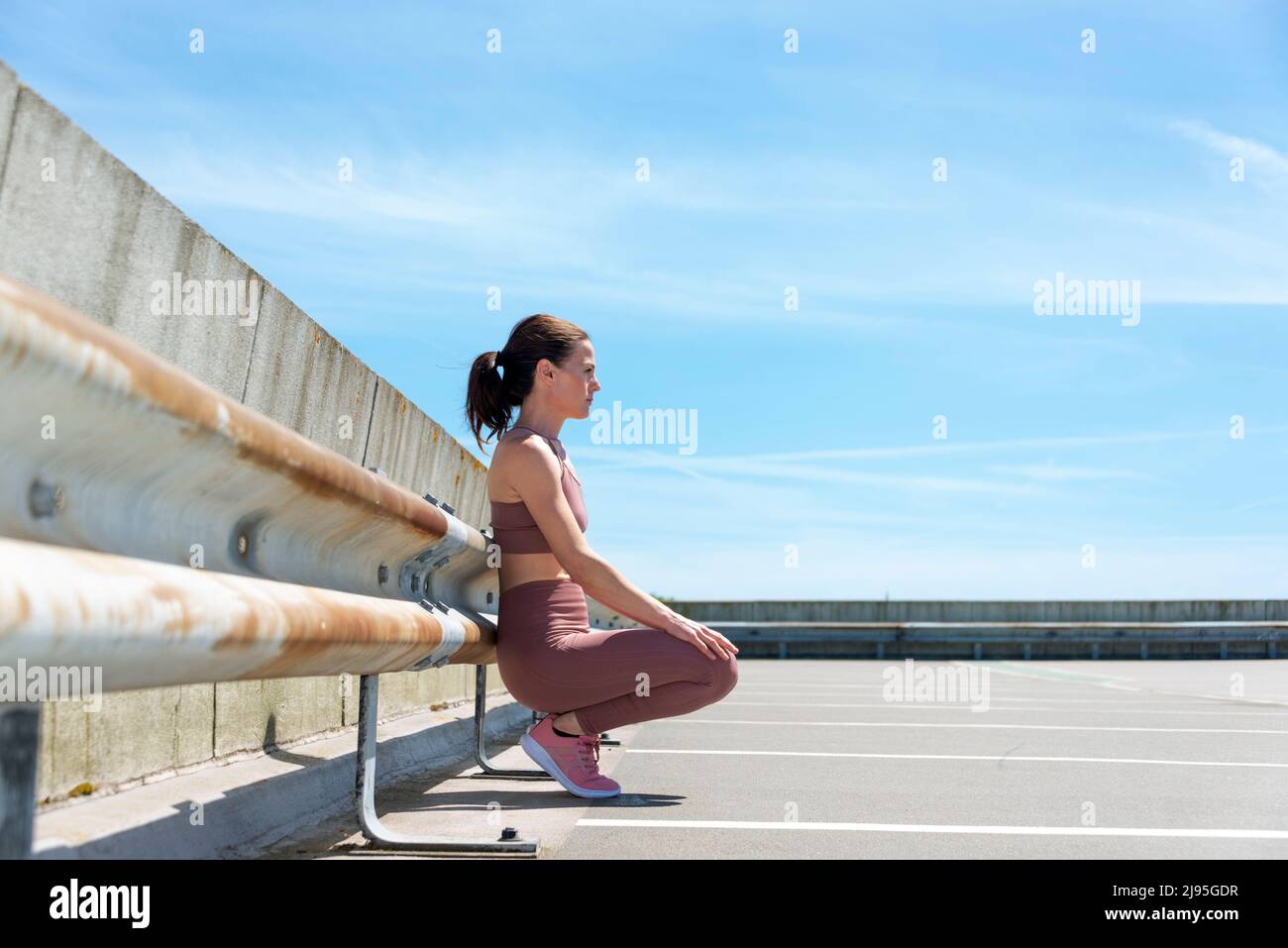 Fit sporty woman sitting, resting after working out outside Stock Photo