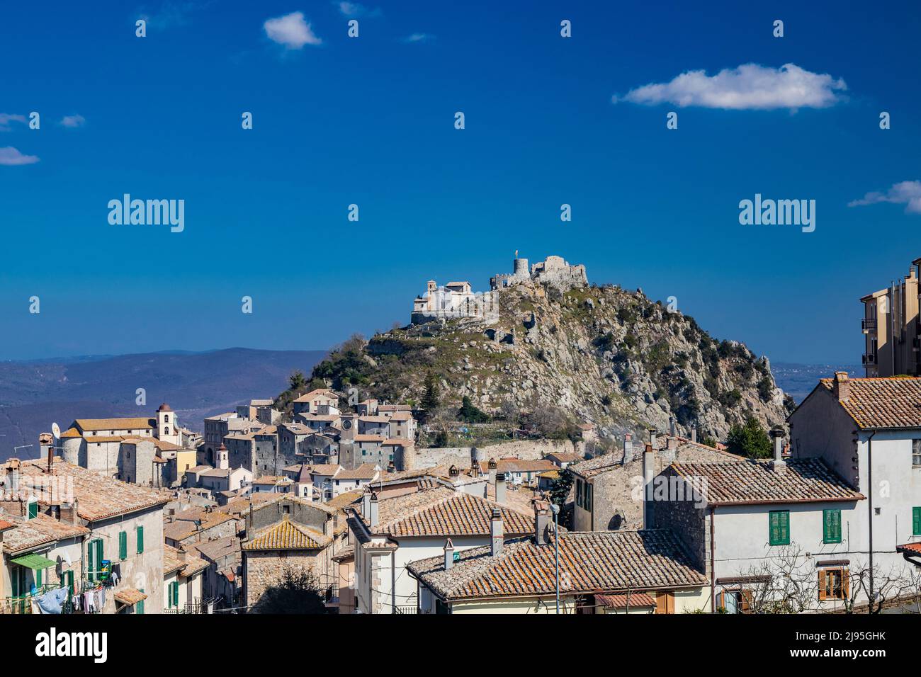 Village of Tolfa, in Lazio. View of the fortress and the church of the Sanctuary at the top of the cliff. The roofs of the houses of the town that ris Stock Photo