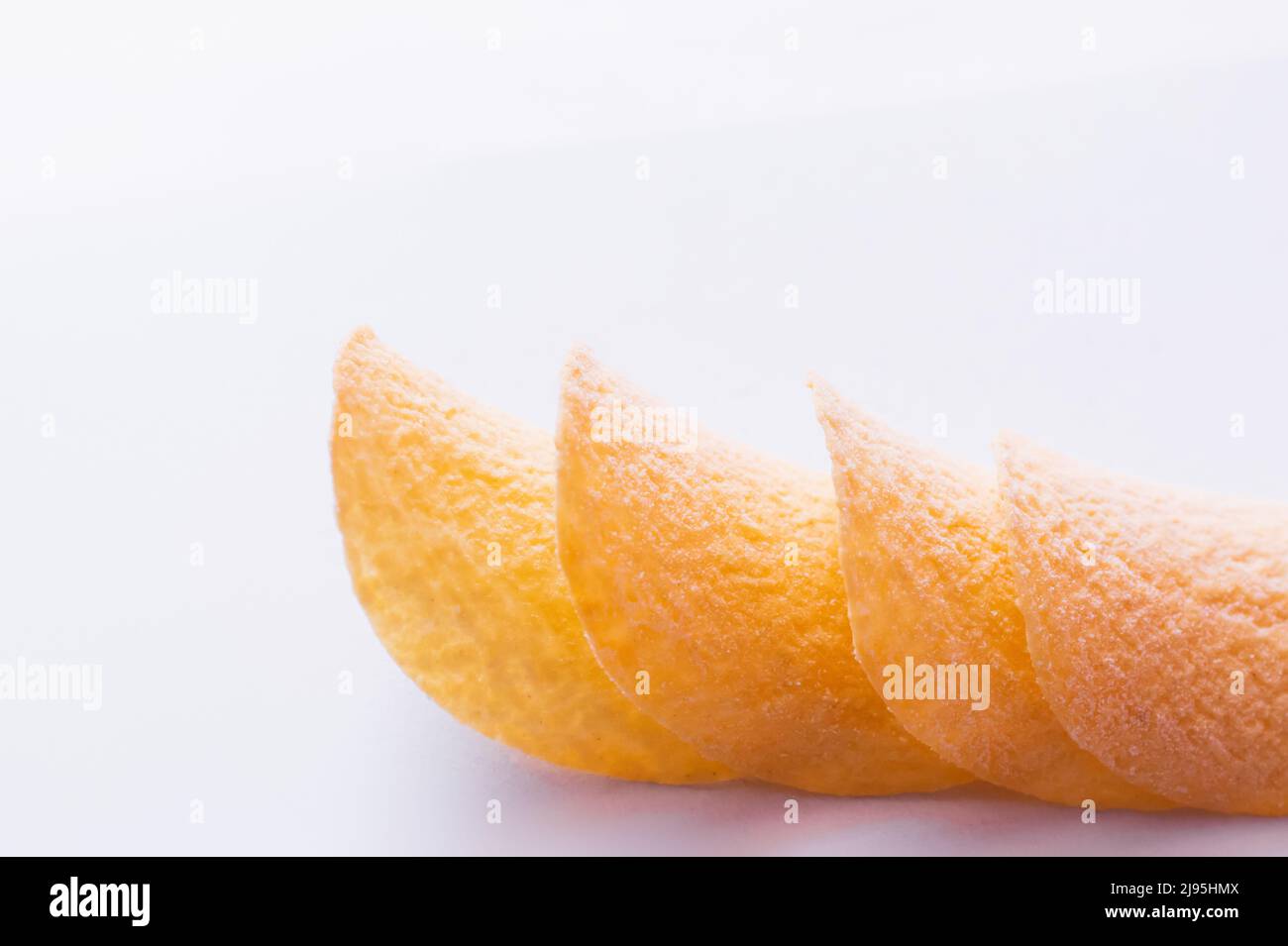 close up of stacked and fried potato chips on white background Stock Photo