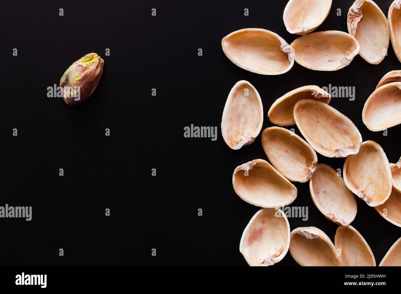 top view of nutshells and tasty pistachio nut isolated on black Stock ...