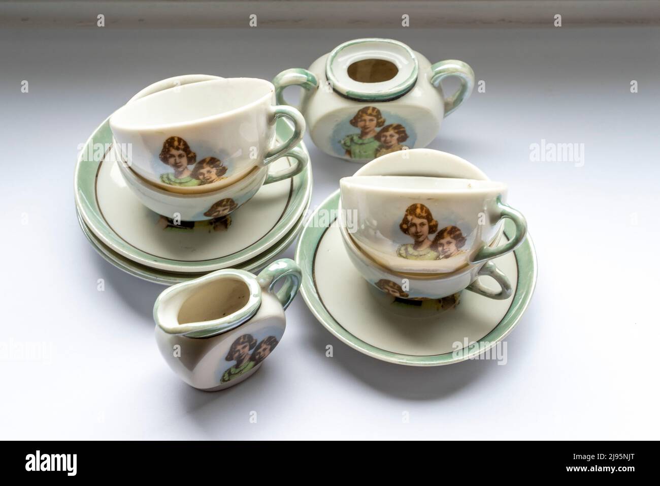 A vintage china childs tea set with photographs of Queen Elizabeth