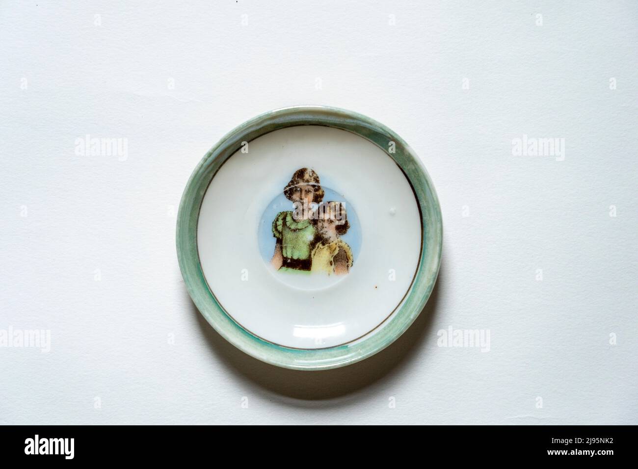 A vintage china childs tea set with photographs of Queen Elizabeth and Sister Princess Margaret as children Stock Photo