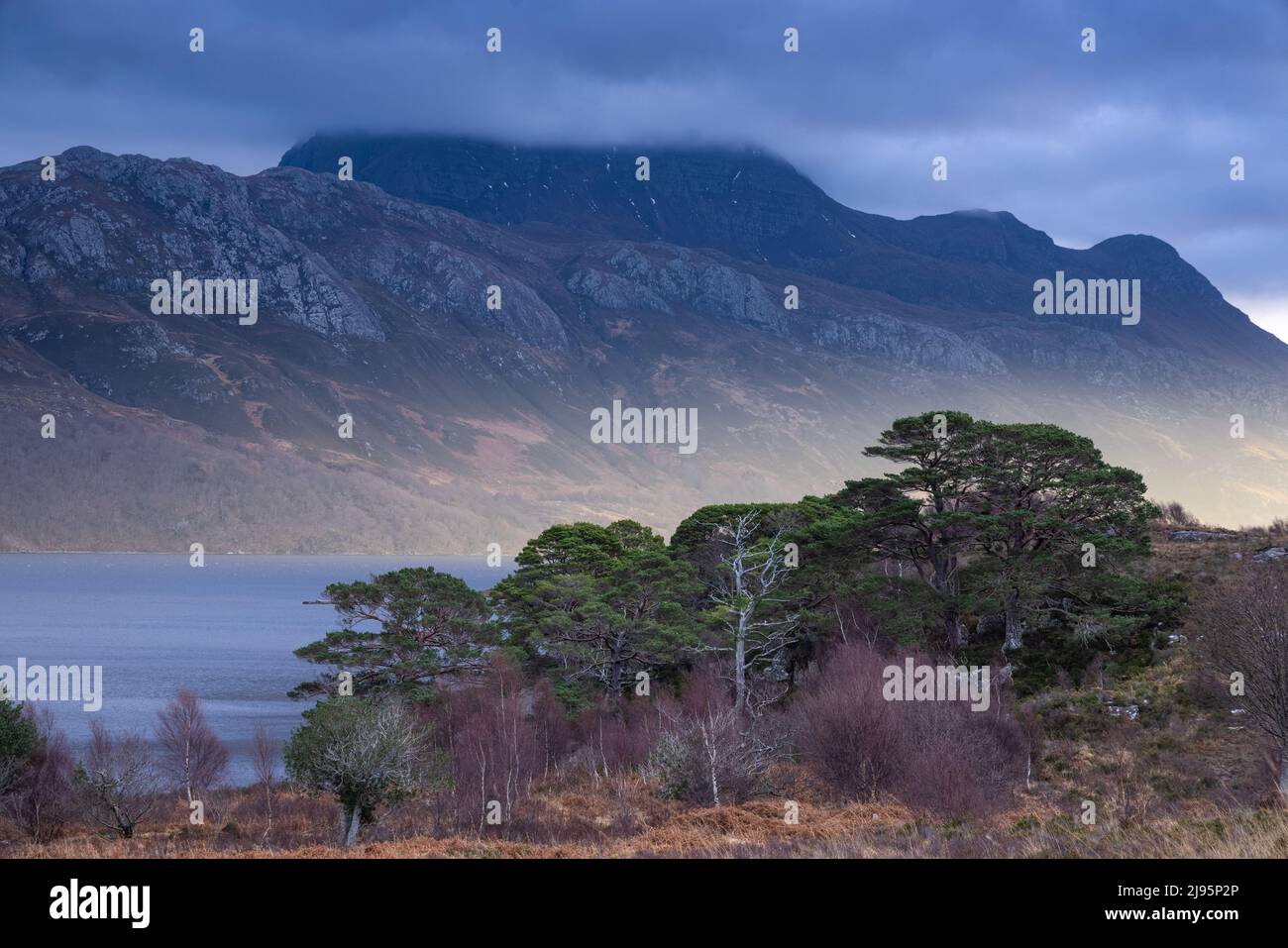 A shaft of low winter light on Loch Maree and Slioch, Wester Ross, Scotland, UK Stock Photo