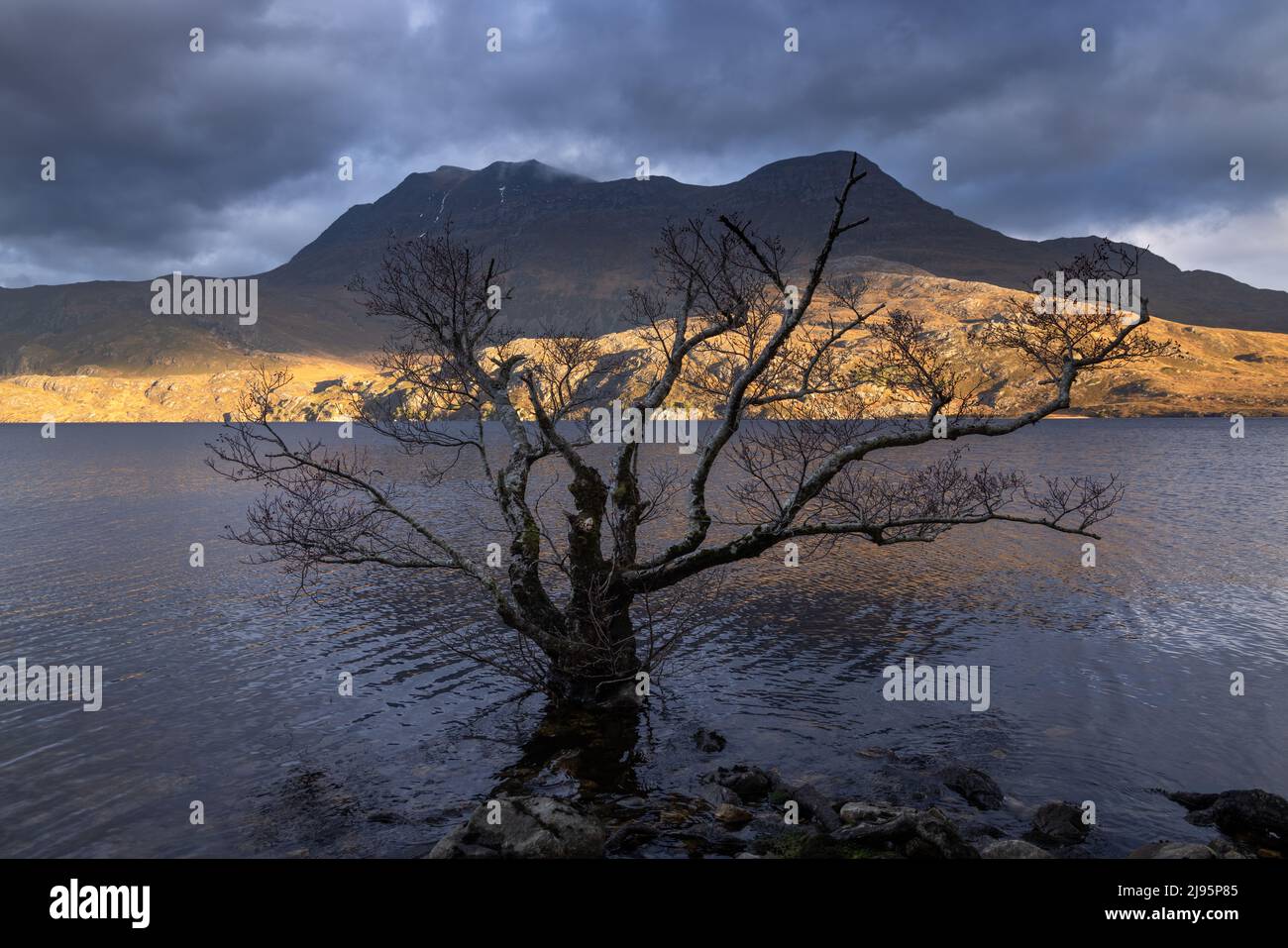 A shaft of low winter light on Loch Maree and Slioch, Wester Ross, Scotland, UK Stock Photo