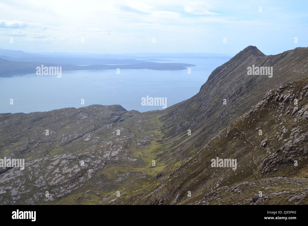 Looking west from the high ridge of Ben Mor Coigach with the opening of Loch Bloom ahead. Wild mountain and coastal scenery in NW Scotland Stock Photo