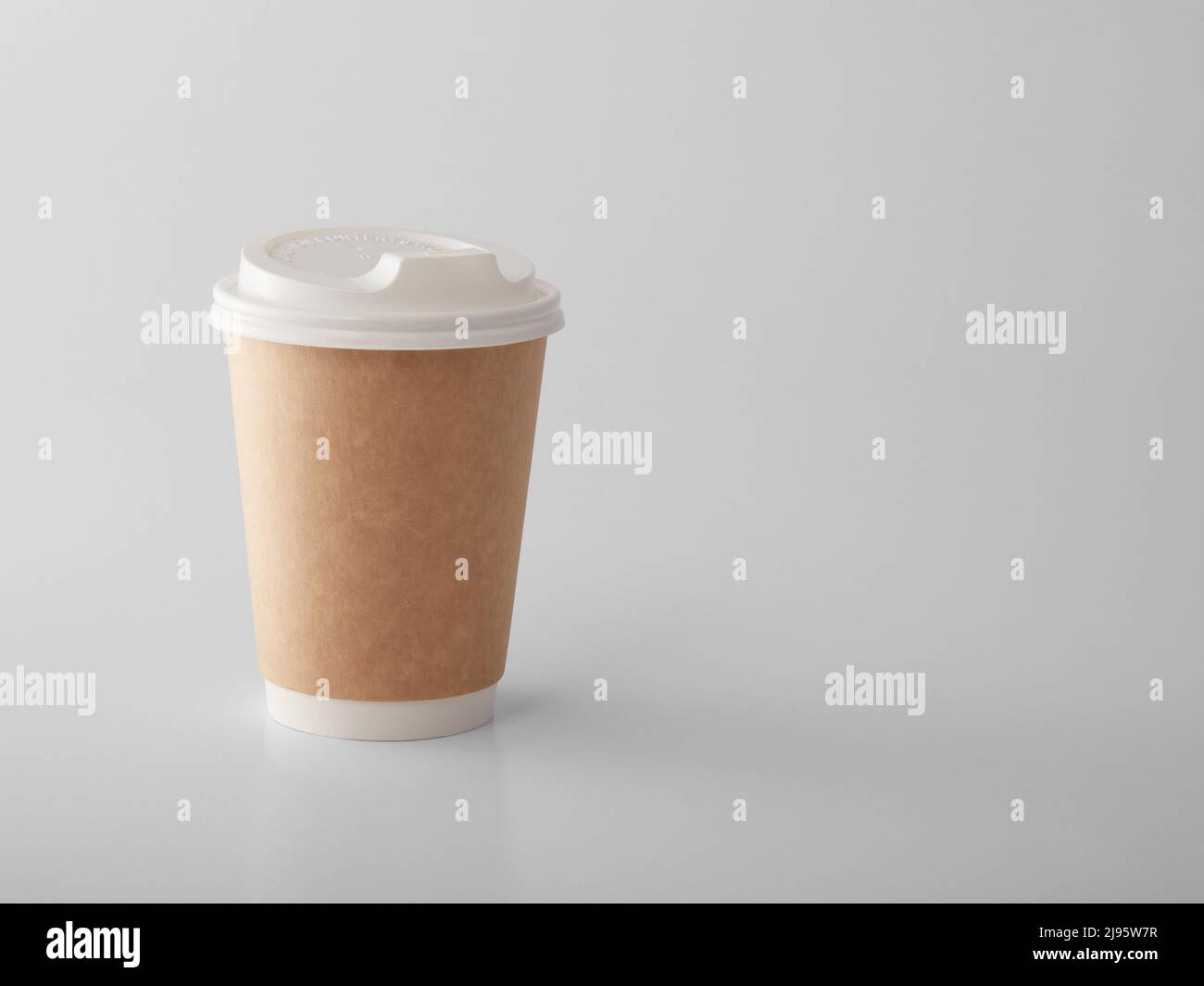 Brown takeaway paper cup with white plastic lid. Stock Photo