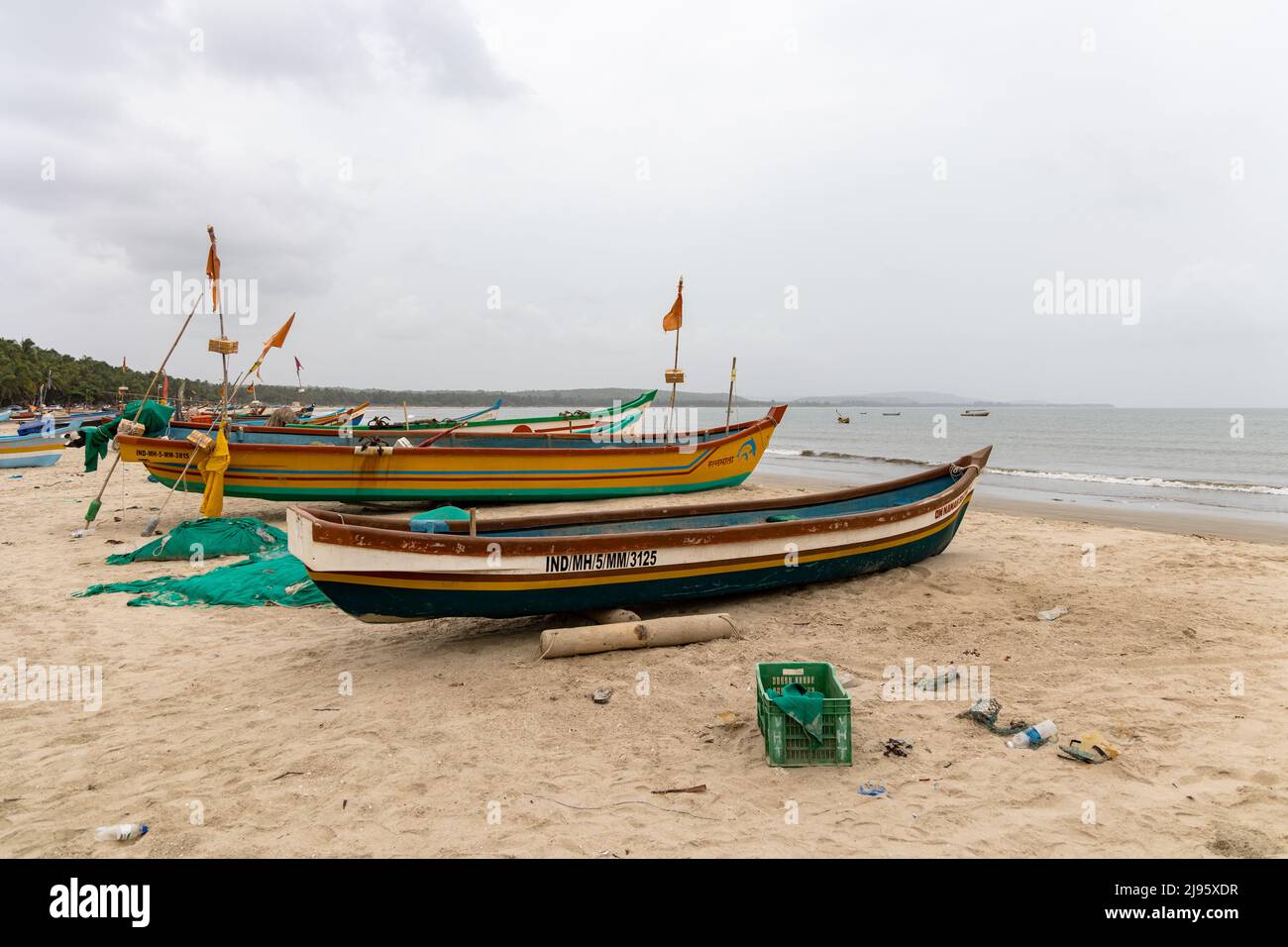 Colourful fishing boats lined on the sandy stretch of Wayari Bhutnath Beach in Malvan, Maharashtra, India Stock Photo