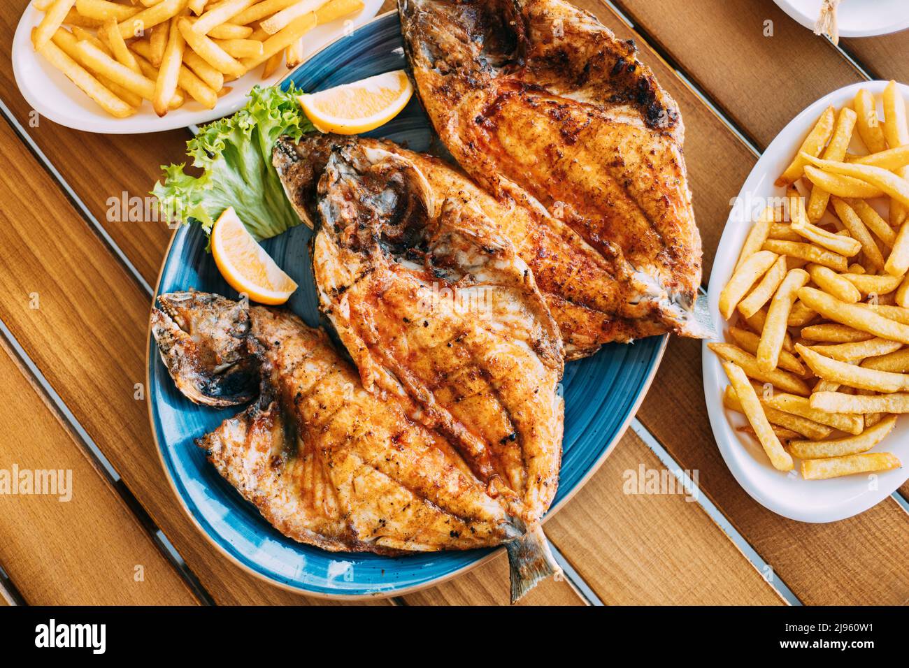 Dish with Gilt-head bream Fish With orange and french fries. Dorada, Dorade, dorado, Dourada fish and chips Stock Photo