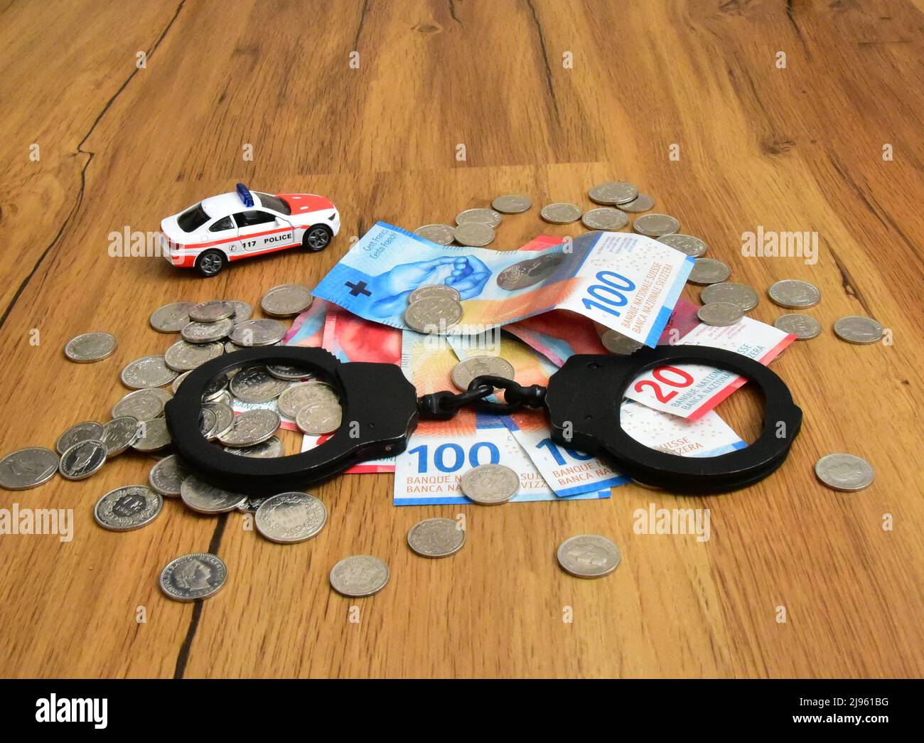 swiss money with handcuffs and toy police car Stock Photo
