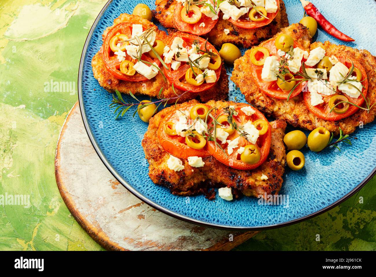 Thin layer of meat, breaded in breadcrumbs with cheese, olives and
