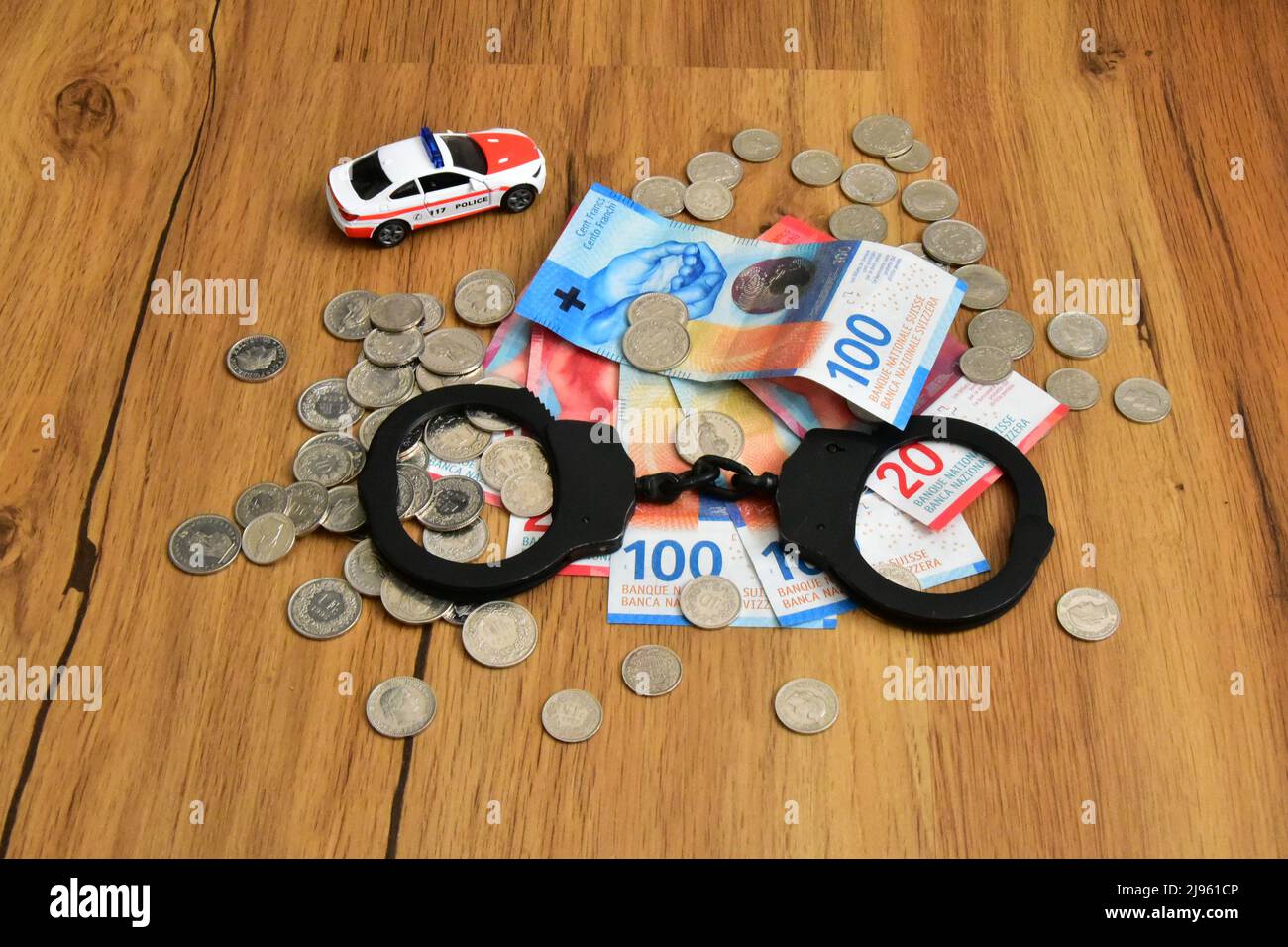 swiss money with handcuffs and toy police car Stock Photo