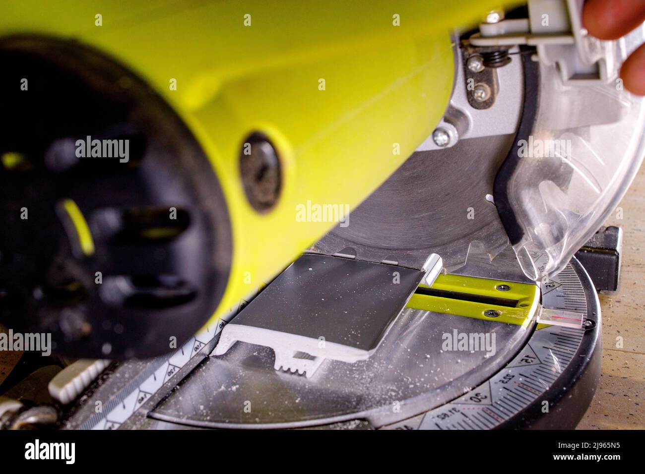 Worker cutting baseboard on the circular saw before installing Stock ...