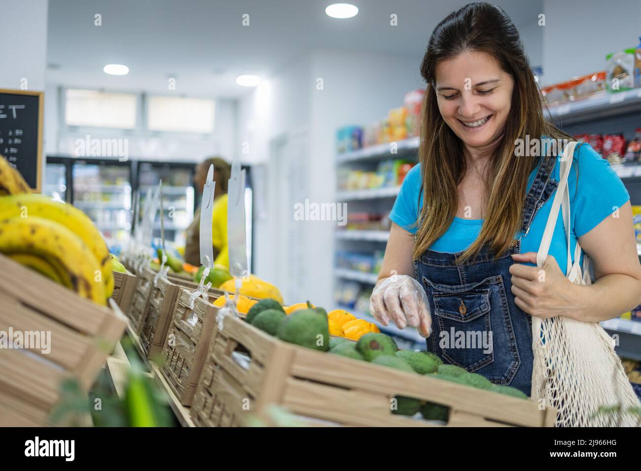 Happy woman buying fresh fruits inside supermarket Stock Photo