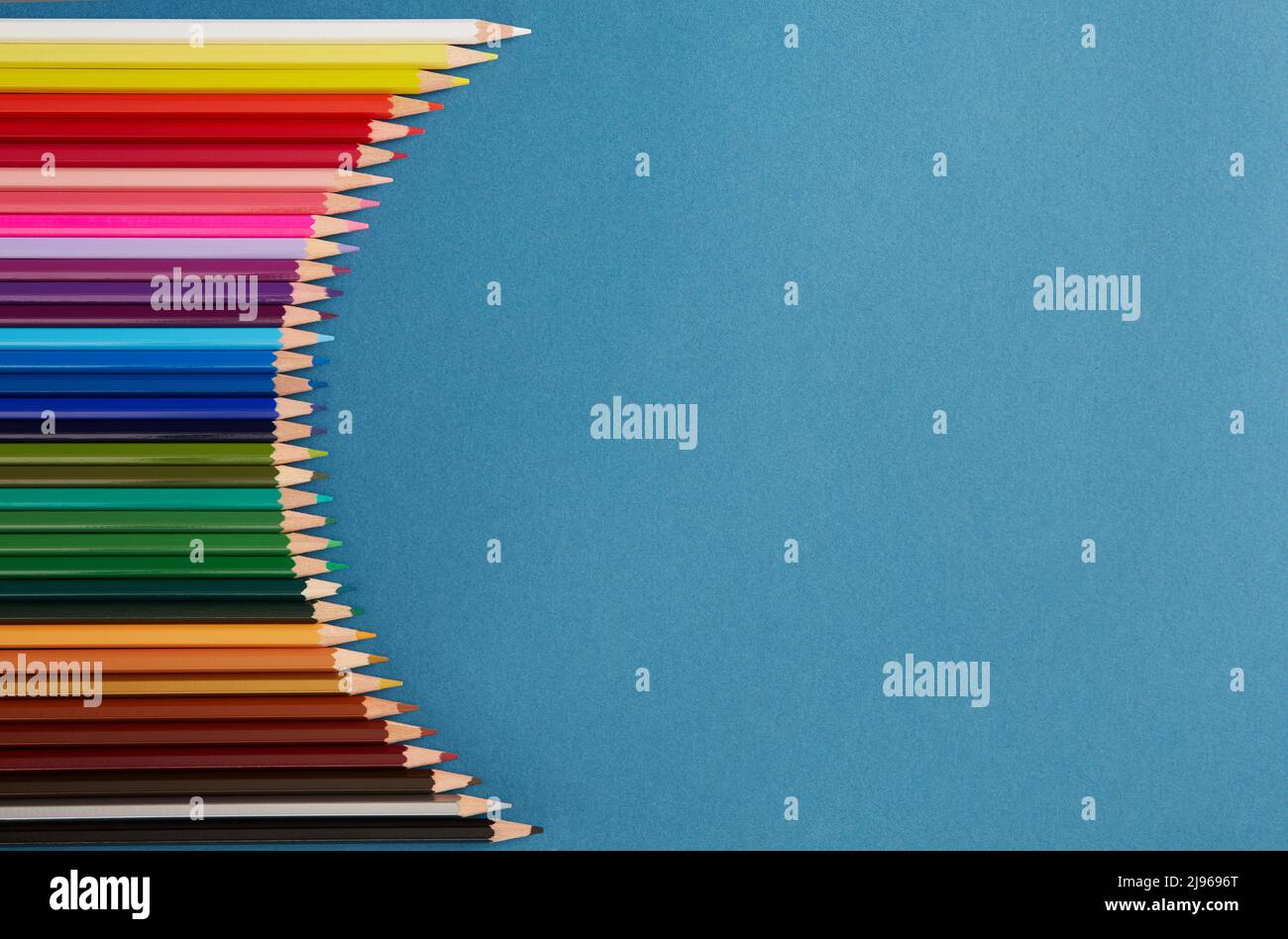 Seamless horizontal pattern Colored pencils arranged in a wave with copy space for note, text, on blue background. Stock Photo