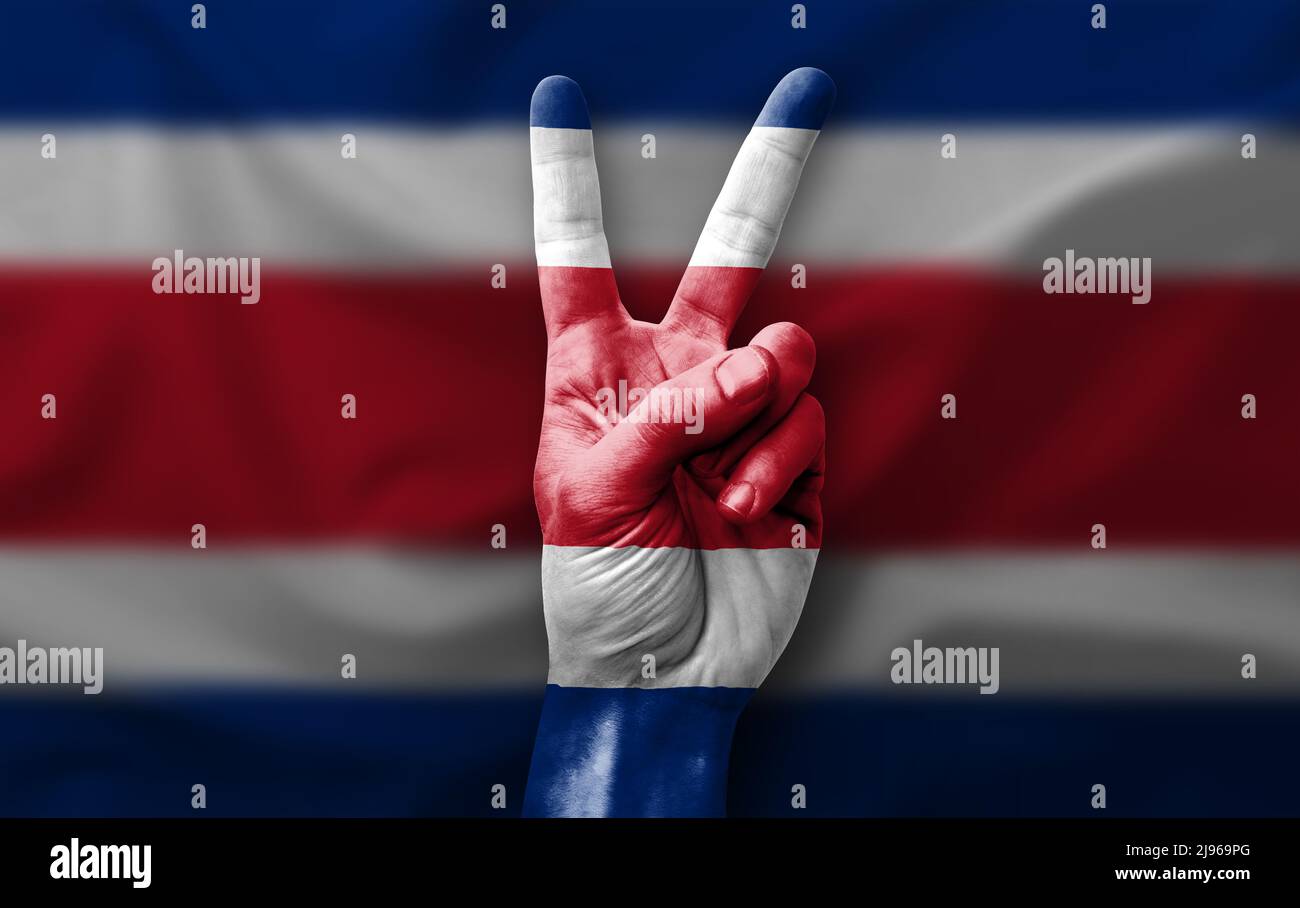 Hand making the V victory sign with flag of costa rica Stock Photo - Alamy