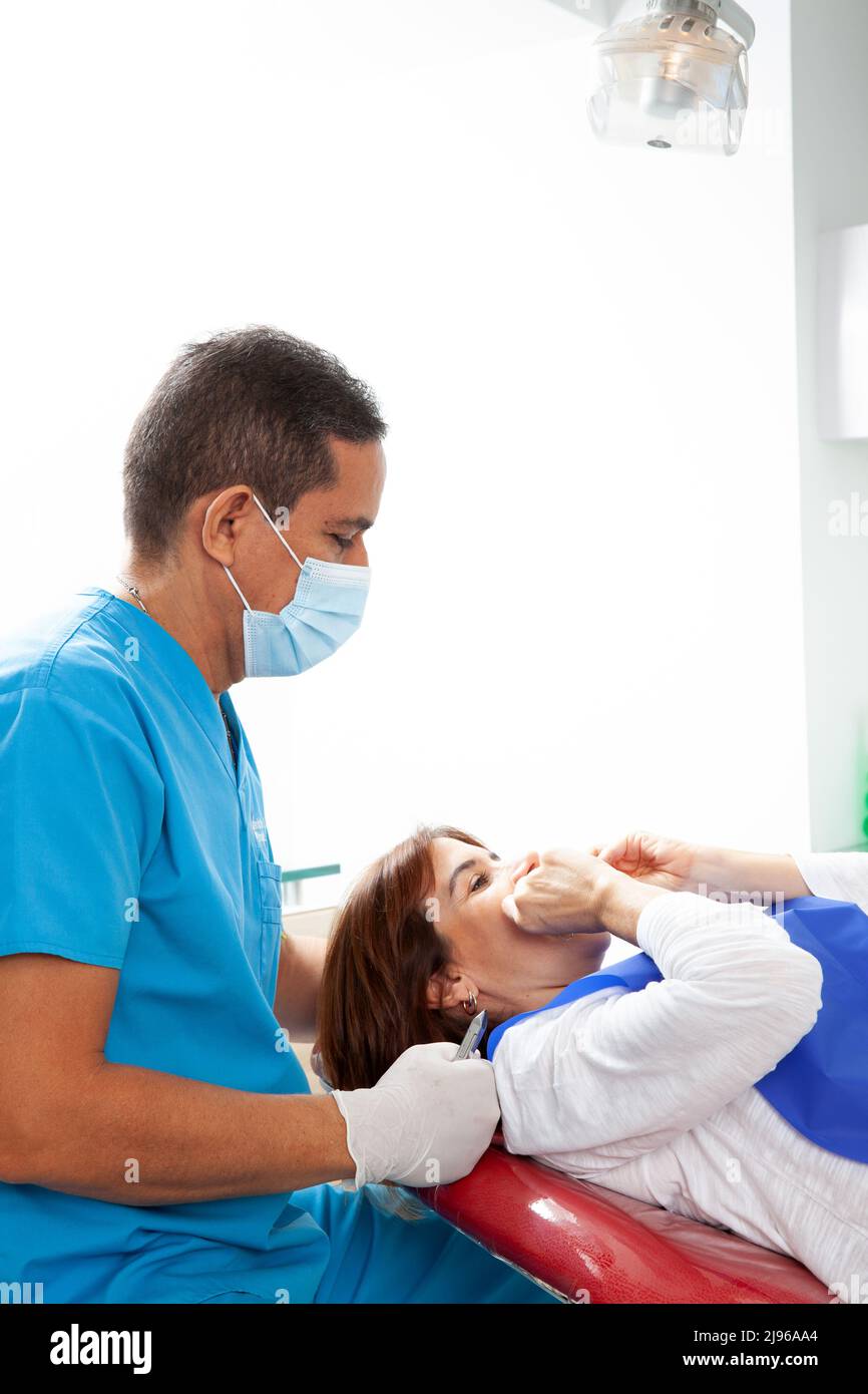 Orthodontic specialist dentist treating an adult female patient Stock
