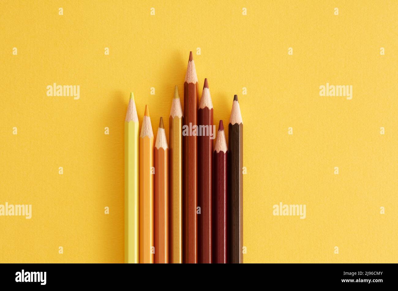 Colored pencils on the yellow background. Stock Photo