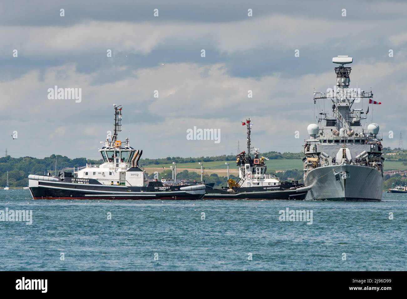 The Royal Navy frigate HMS Kent (F78) being assisted by naval base tugs in Portsmouth Harbour, UK after a families day at sea on the 20th May 2022.. Stock Photo