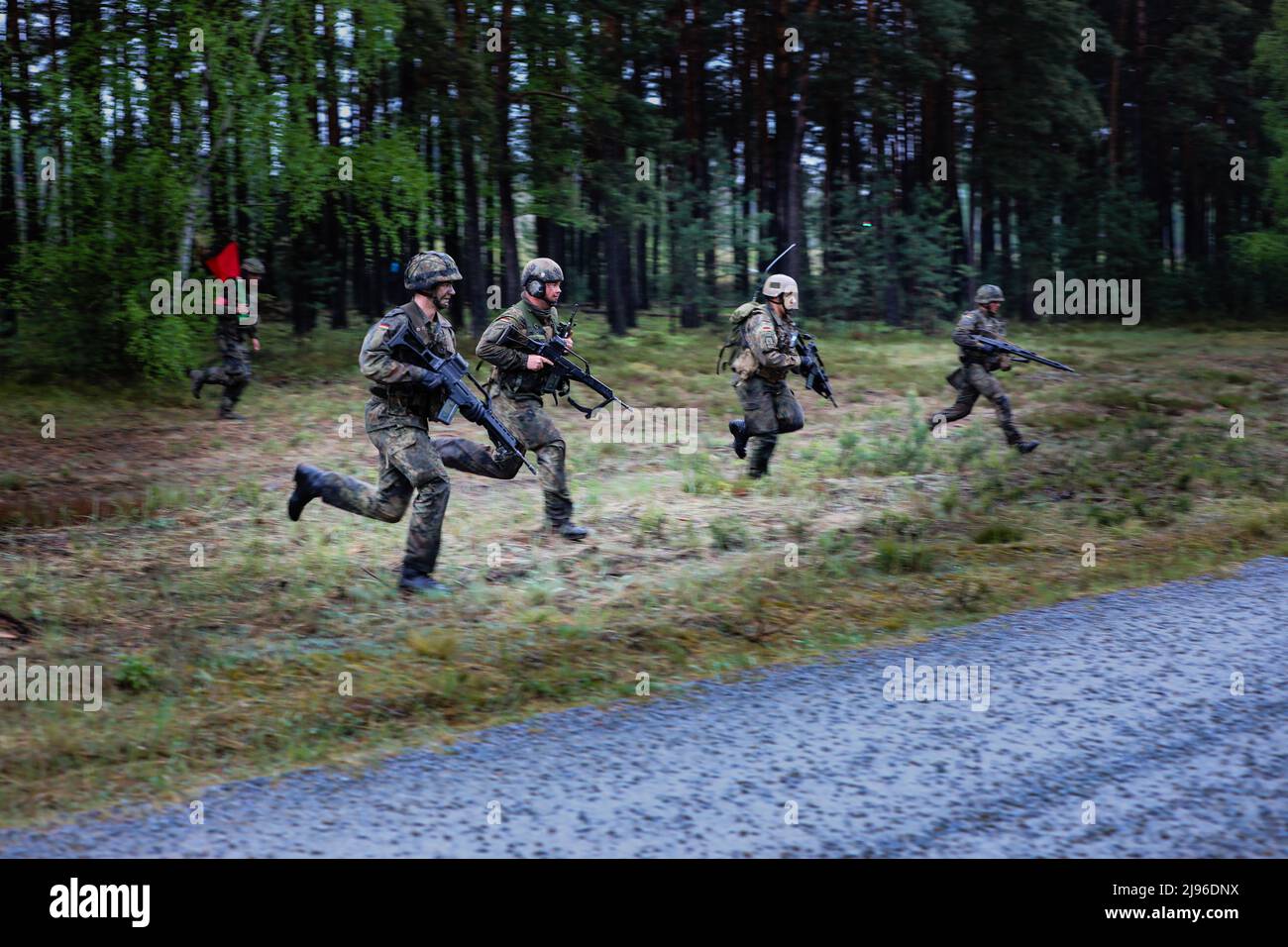 German soldiers assigned to the 212th Panzergrenadier Battalion, 21st Panzer Brigade, 1st Panzer Division, advance to their target during a live-fire exercise as part of Defender Europe at Oberlausitz Training Area, Germany, May 17, 2022. Defender Europe 22 is a series of U.S. Army Europe and Africa multinational training exercises in Eastern Europe. The exercise demonstrates U.S. Army Europe and Africa’s ability to conduct large-scale ground combat operations across multiple theaters supporting NATO. (U.S. Army National Guard photo by Staff Sgt. Gabriel Rivera) Stock Photo