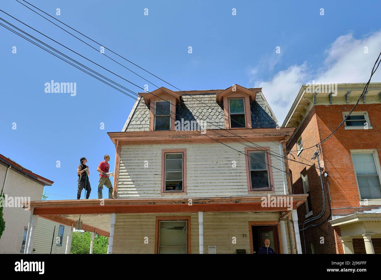 Two men restore a slate roofed house in historic Port Deposit, MD