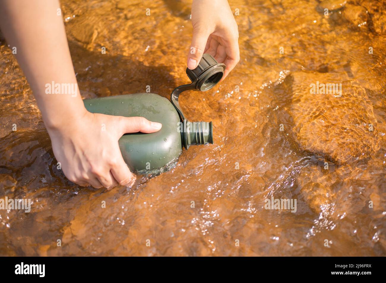 Woman taking pure water to bottle from mountain stream during trekking in  mountains. Hiker crouching on rocks, filling bottle up with cold mountain  wa Stock Photo - Alamy