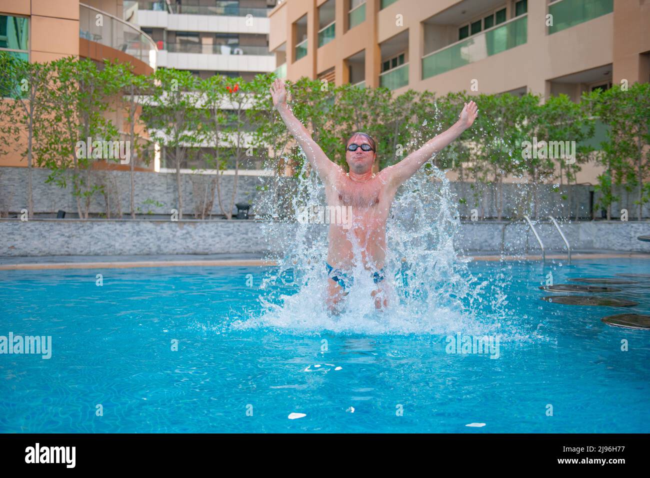 guy jumping up in the big pool Stock Photo