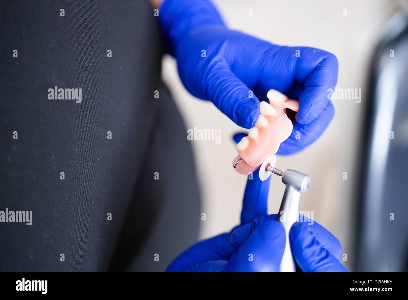 Dentist's hands finishing a polishing dental prosthesis. Composite restorations. Dental polisher Stock Photo