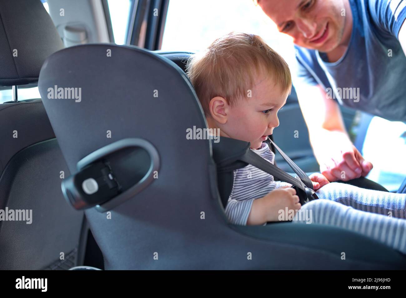 Father placing his little boy in the car seat Stock Photo Alamy