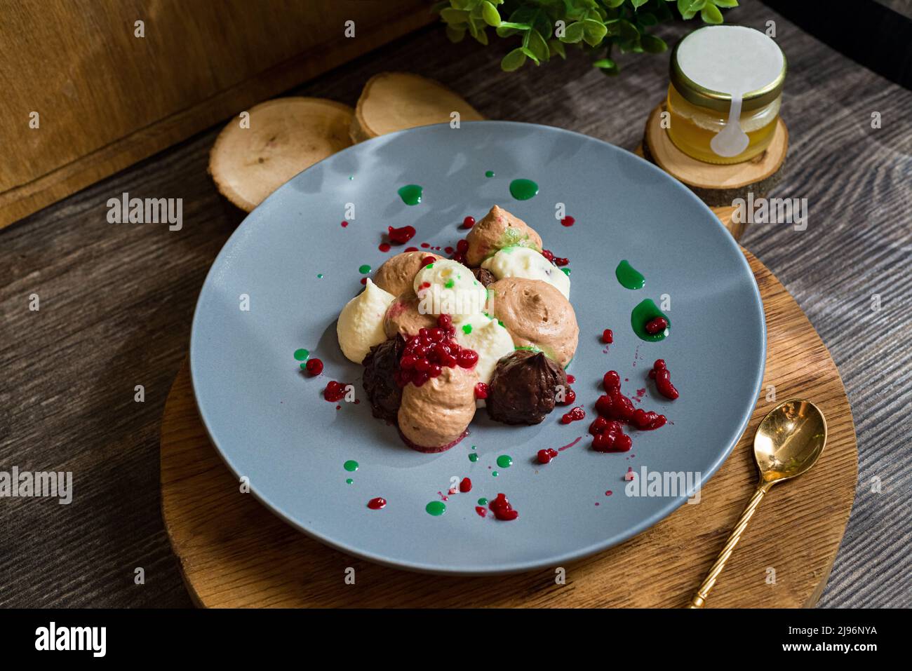 Three chocolate mousse with raspberry caviar. Dessert on a plate. Dark moody food photo. Stock Photo