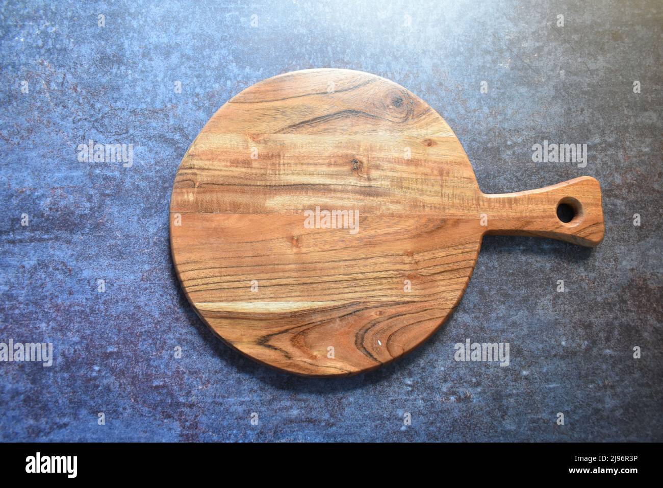 Round empty wooden chopping board made from acacia wood Stock Photo