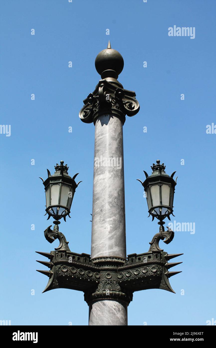 Vintage marble and bronze lamp post with lamp supports shaped like the hull of a ship (the symbol of Paris) outside the Paris Opera House. Stock Photo