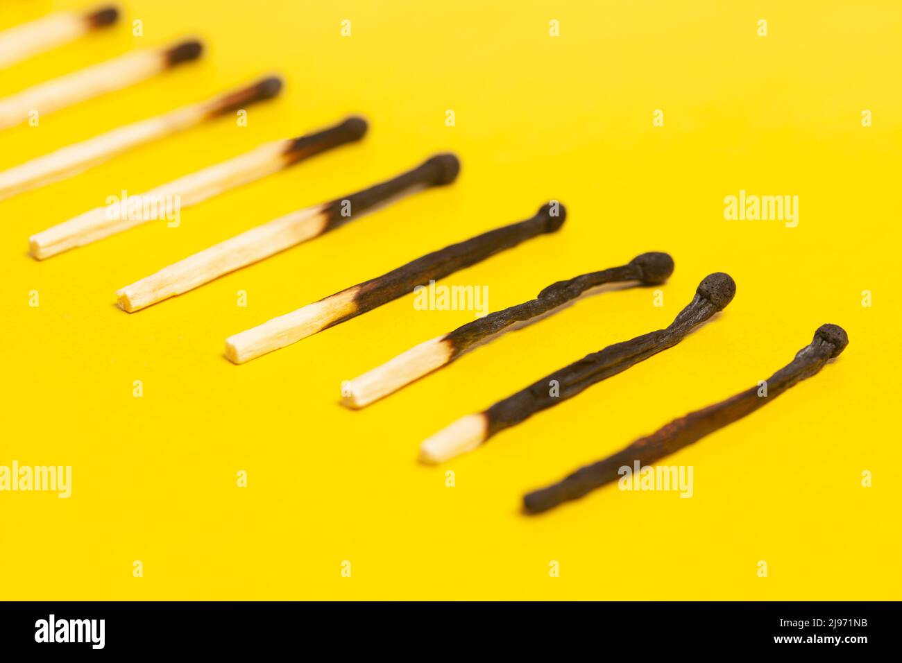 Different stages of match burning. Burnt matches on yellow background