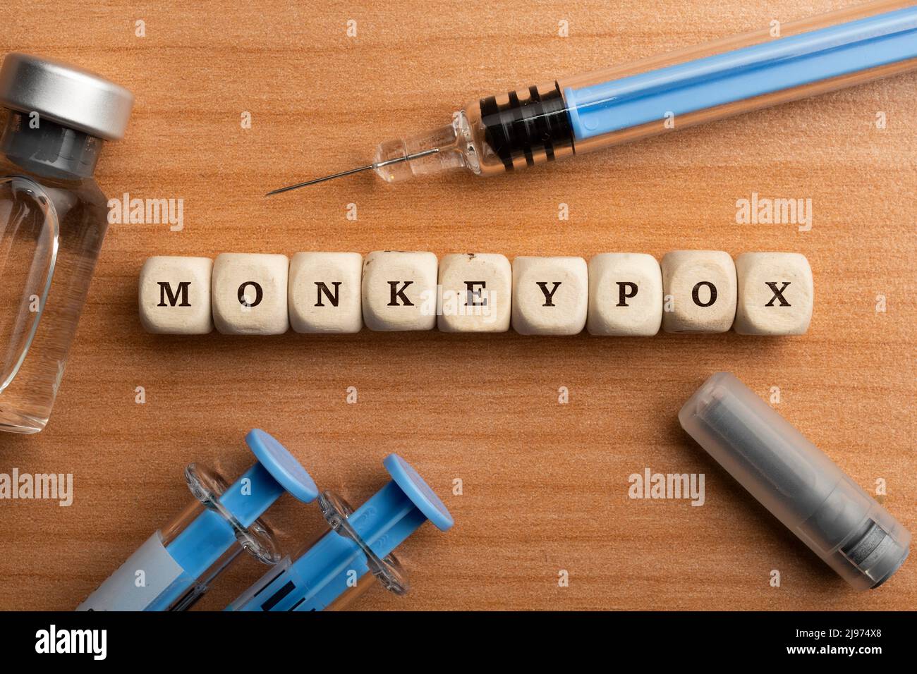 Monkeypox pandemic concept: dice surrounded by syringes and vials make up the word monkeypox Stock Photo