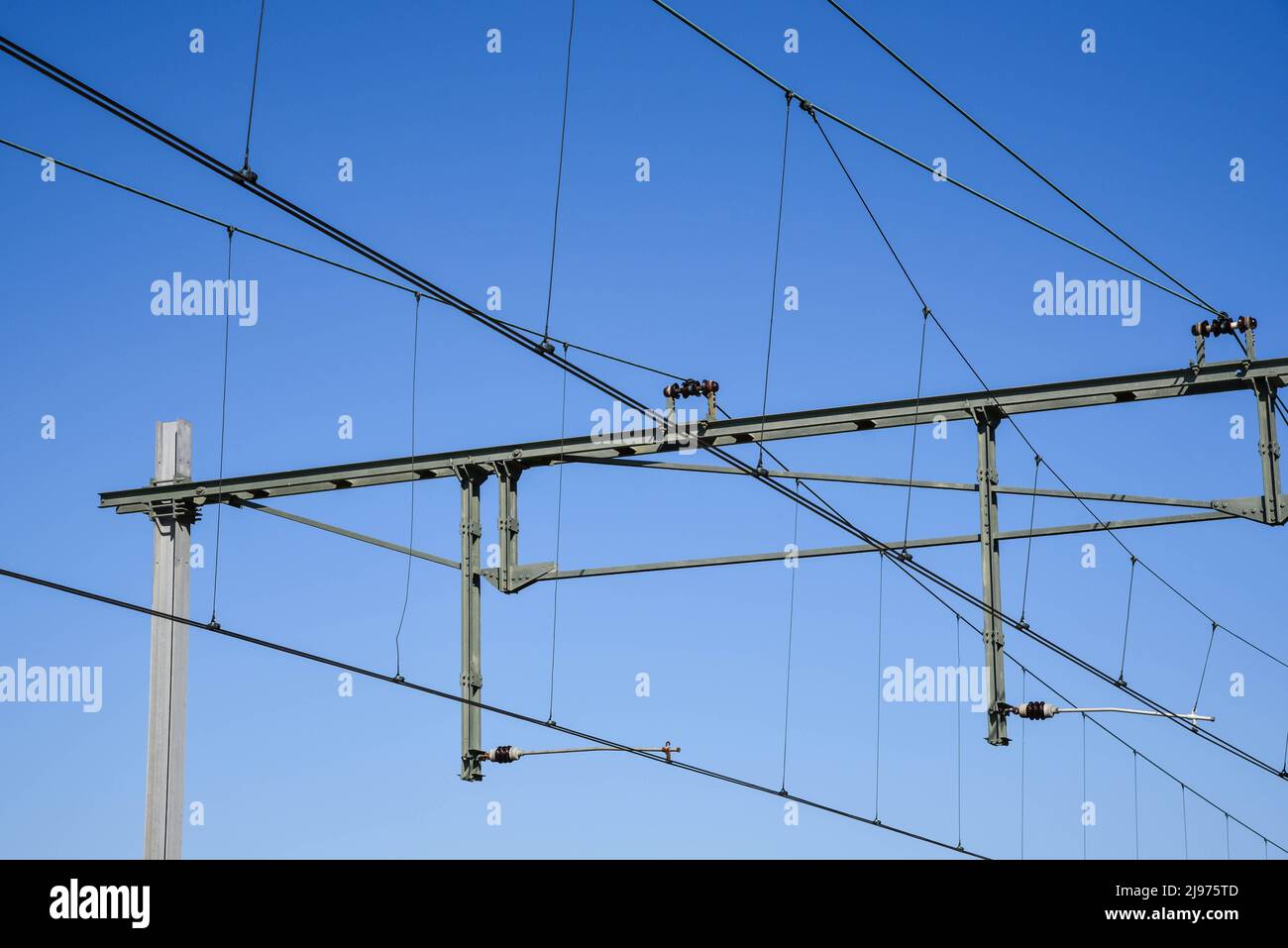Den Helder, Netherlands, May 2022. The railroad catenary against a blue sky. High quality photo Stock Photo