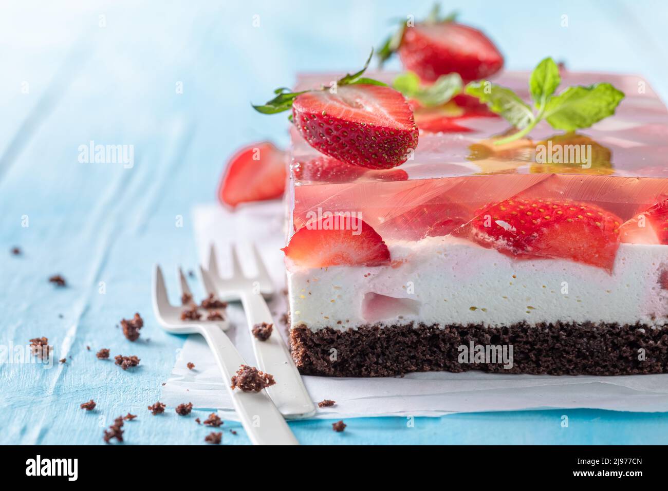 Fresh strawberry jelly cake with fluffy cream layer. Gelatin cake with